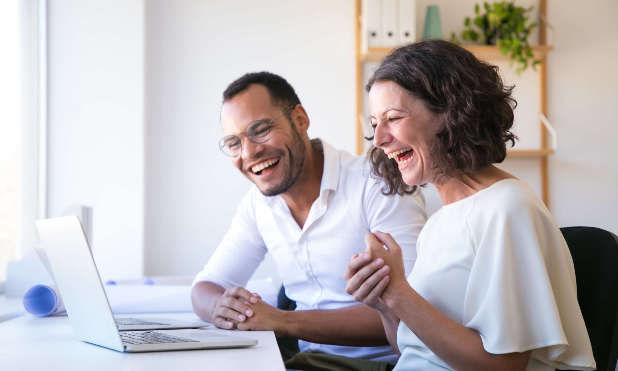 cheerful employees looking laptop laughing